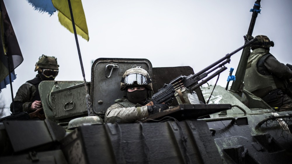 Ukrainian soldiers are seen in an armoured vehicle topped with a Ukrainian flag near the city of Artemivsk, in the Donetsk region, before heading to the city of Debaltseve on Feb., 1, 2015. (Photo by Manu Brabo/AFP/Getty)