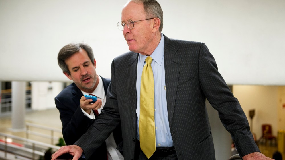 Sen. Lamar Alexander talks with reporters on the way to the Senate policy luncheons in the U.S. Capitol, Jan. 14, 2014.