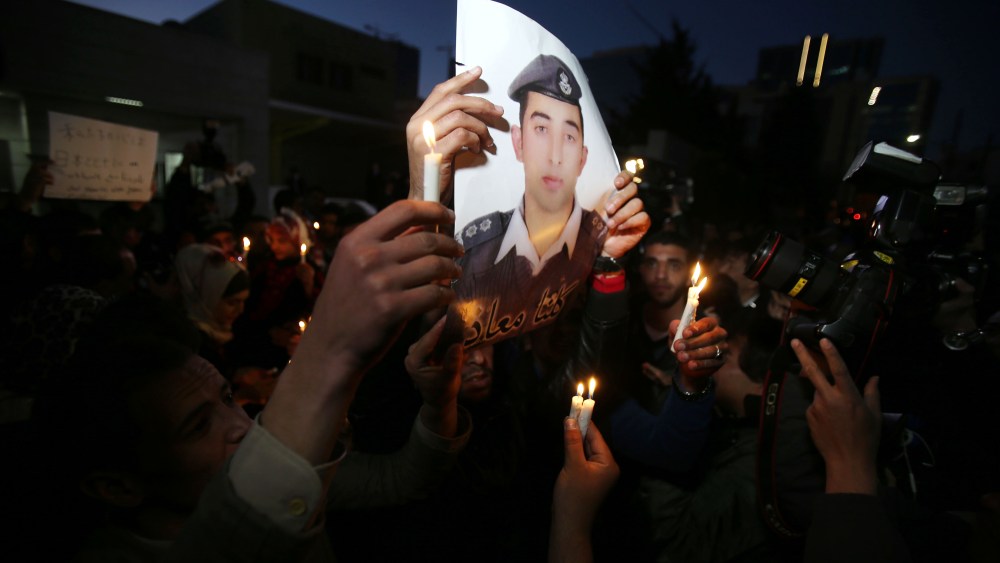 Jordanian youth hold a picture of pilot Muath Al Kasasbeh, who was a hostage of the Islamic State, as they gather for a vigil to condemn the killing of two Japanese hostages in Amman, Jordan, on Feb. 2, 2015. (Photo by Jordan Pix/Getty)