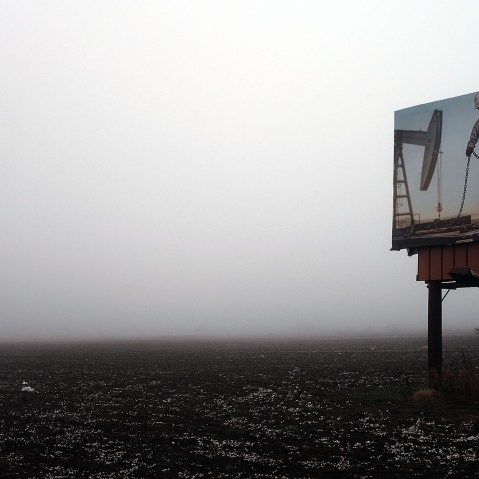 A picture of an oil worker is viewed on a billboard along land that is being fitted with pipeline on Feb. 4, 2015 in Sweetwater, Texas. (Photo by Spencer Platt/Getty)
