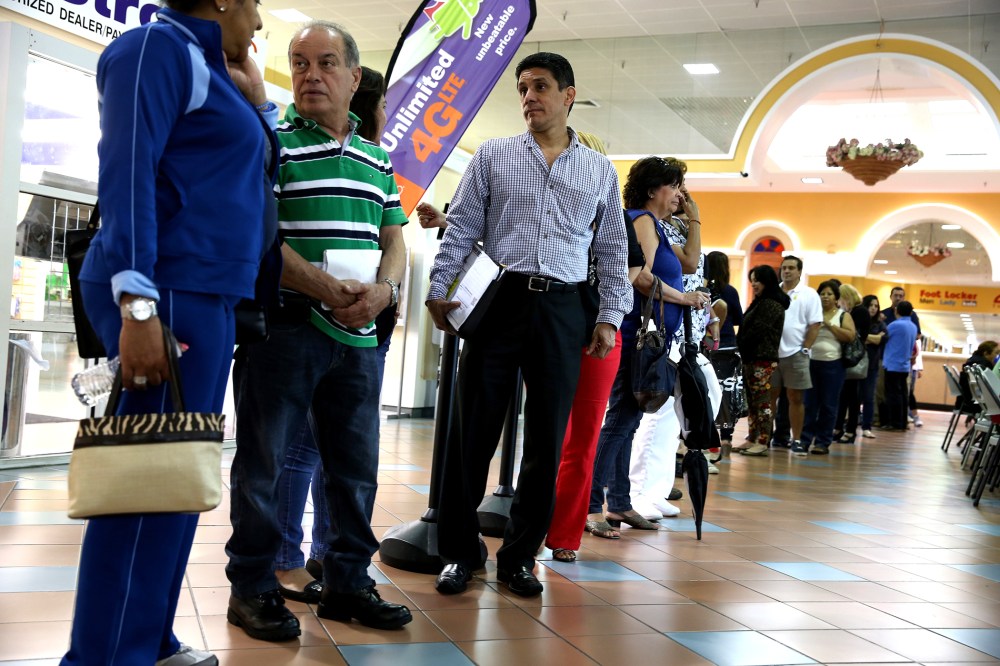 People waiting to speak with an insurance agent as they try to purchase health insurance under the Affordable Care Act at the kiosk setup at the Mall of Americas on Jan. 15, 2014 in Miami, Florida.