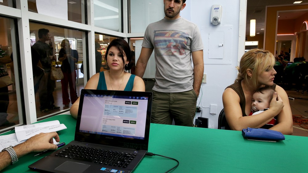 Dailem Delombard, Ronnie Cabrera and Maylin Lezcano sit with an insurance agent from Sunshine Life and Health Advisors in Miami, Jan. 5, 2014.