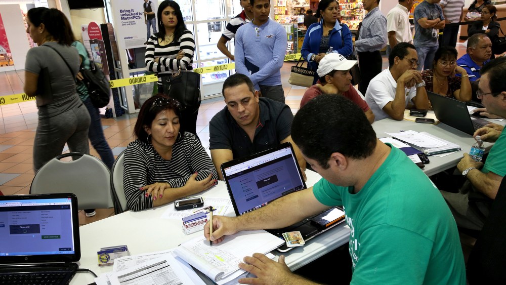 People stand in line to speak with an insurance to purchase health insurance under the Affordable Care Act on Jan. 15, 2014 in Miami, Fla. (Photo by Joe Raedle/Getty)