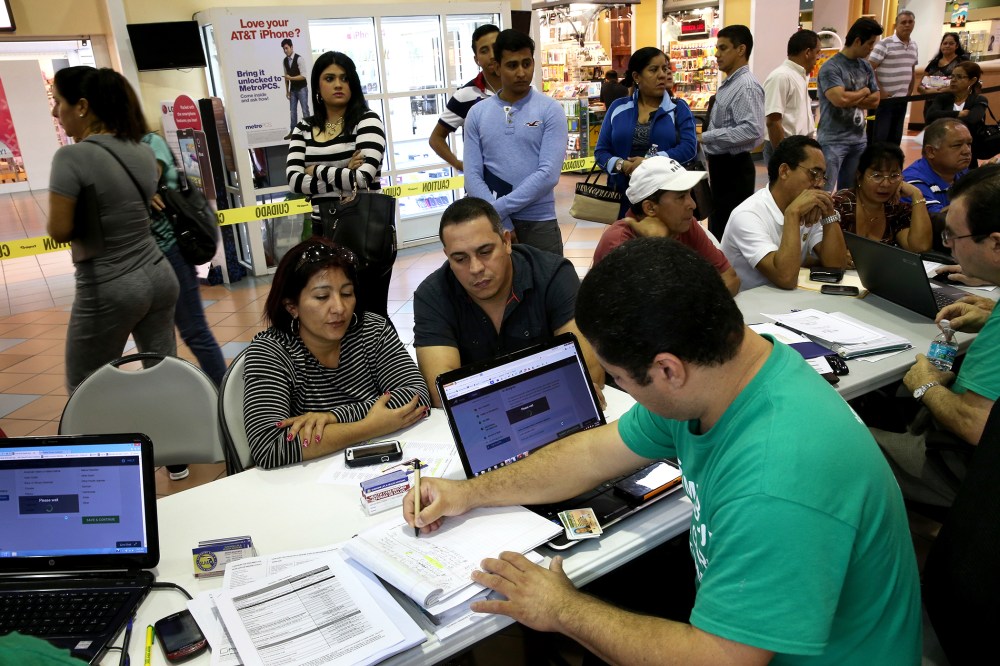 People stand in line to speak with an insurance to purchase health insurance under the Affordable Care Act on Jan. 15, 2014 in Miami, Fla. (Photo by Joe Raedle/Getty)
