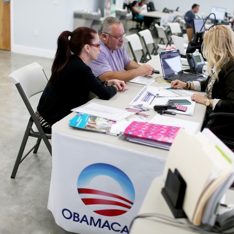 Aymara Marchante (L) and Wiktor Garcia sit with Maria Elena Santa Coloma,(R) an insurance advisor with UniVista Insurance company, as they sign up for the Affordable Care Act on Feb. 5, 2015 in Miami, Fla. (Photo by Joe Raedle/Getty)