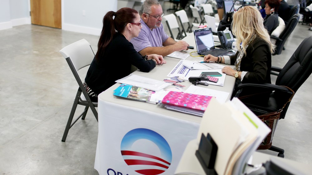 Aymara Marchante and Wiktor Garcia sit with UniVista insurance advisor Maria Elena Santa Coloma as they sign up for the Affordable Care Act, also known as Obamacare, on Feb. 5, 2015 in Miami, Florida. (Photo by Joe Raedle/Getty)