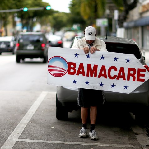 Pedro Rojas holds a sign directing people to an insurance company where they can sign up for the Affordable Care Act, also known as Obamacare, before the February 15th deadline on Feb. 5, 2015 in Miami, Fla. (Photo by Joe Raedle/Getty)