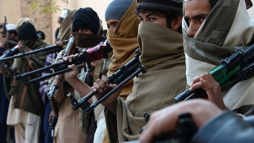 Afghan former Taliban fighters are photographed holding weapons before they hand them over as part of a government peace and reconciliation process at a ceremony in Jalalabad on Feb. 8, 2015. (Photo by Noorullah Shirzada/AFP/Getty)