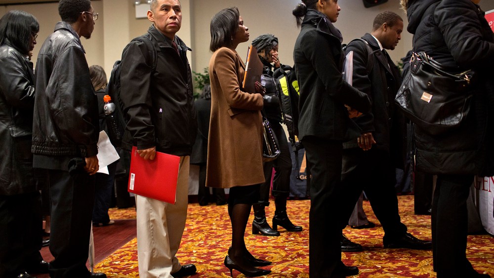 Job seekers wait to talk to recruiters and fill out applications at a job fair in New York, U.S., on Jan. 16, 2014.