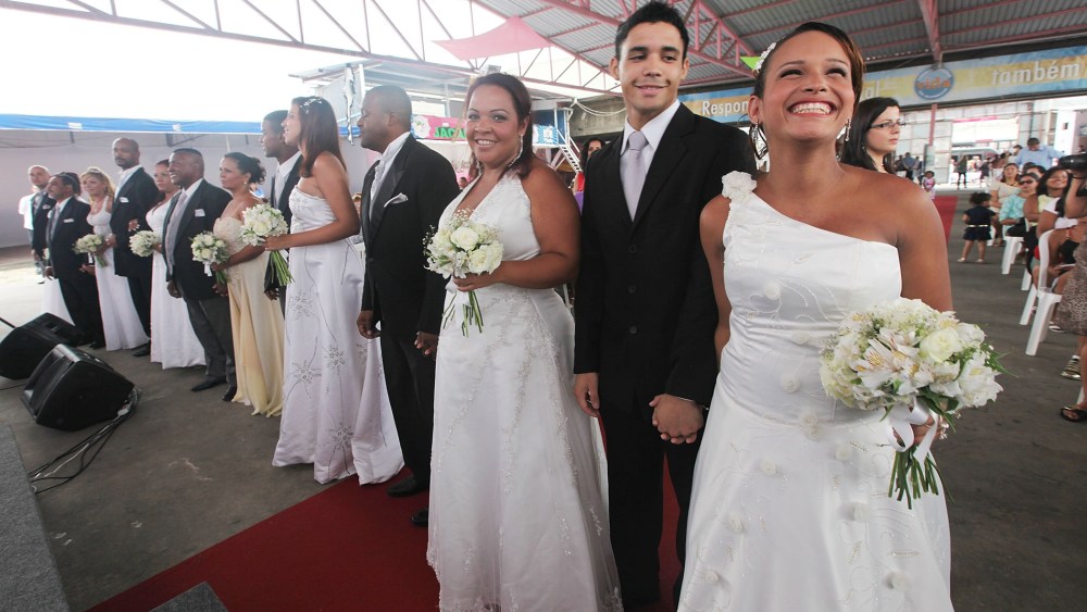 Bride Michelle Nogueira (R) and groom Wellington Costa (2nd R) stand before marrying in a communal marriage ceremony in the Jacarezinho pacified community, or shantytown, on January 17, 2014 in Rio de Janeiro, Brazil.