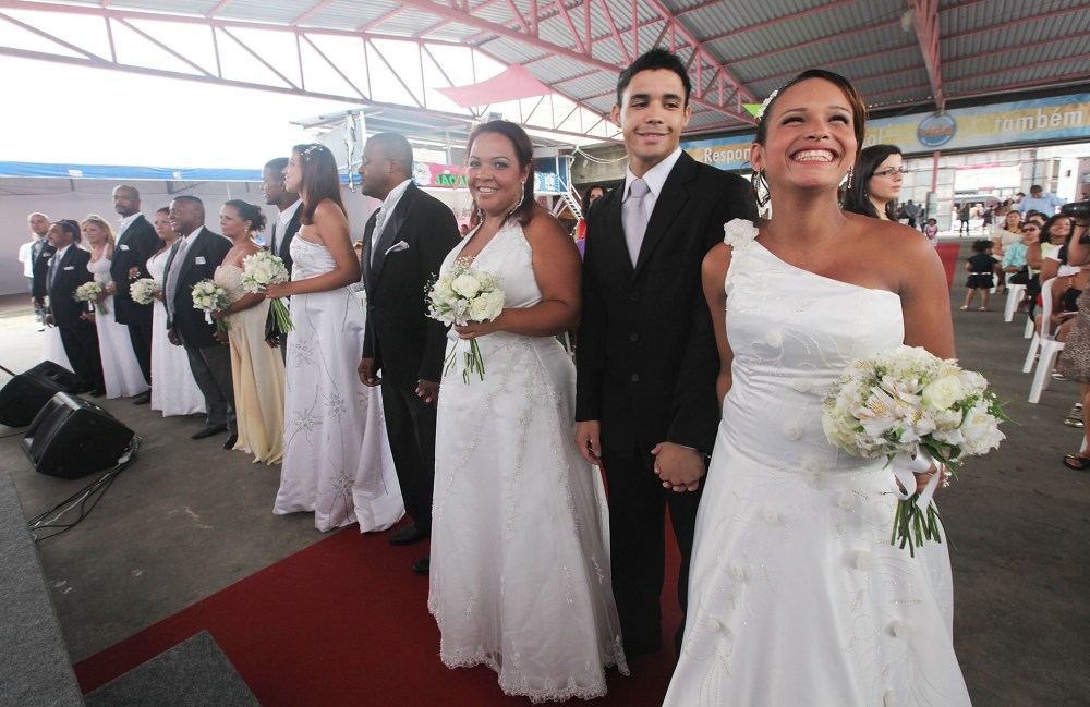 Bride Michelle Nogueira (R) and groom Wellington Costa (2nd R) stand before marrying in a communal marriage ceremony in the Jacarezinho pacified community, or shantytown, on January 17, 2014 in Rio de Janeiro, Brazil.