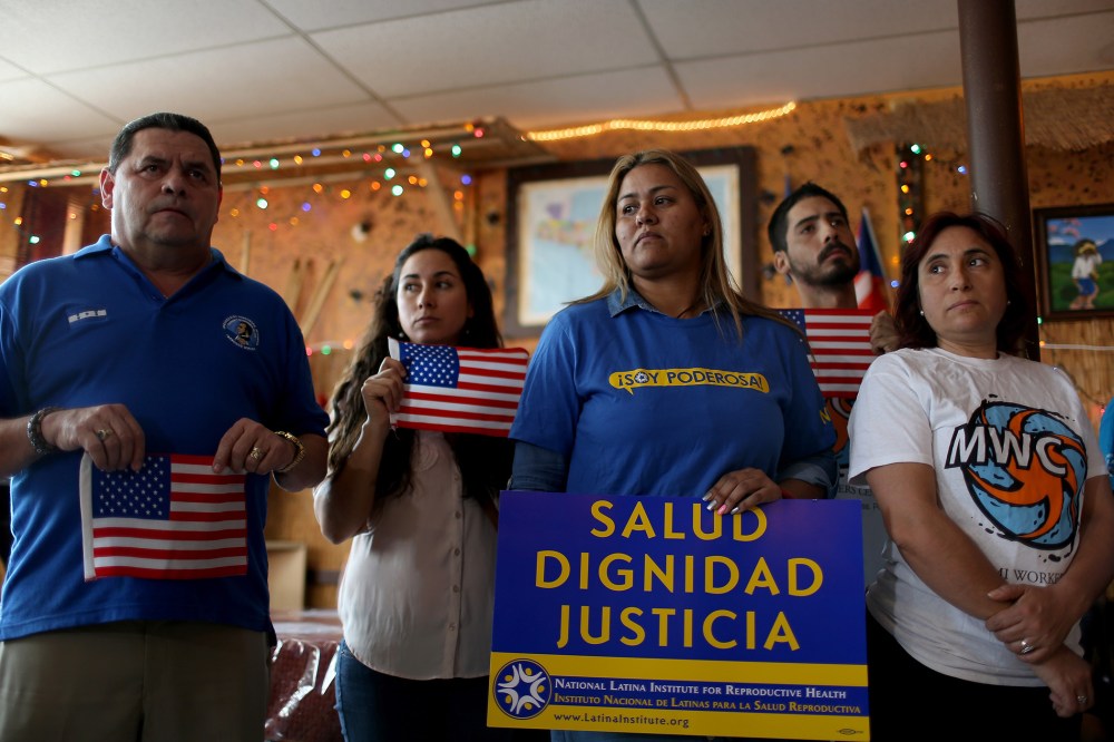 People stand together as they hold a press conference to protest the district court judge in Brownsville, Texas, who issued a preliminary injunction that temporarily blocks the implementation process of President Barack Obama's Executive Action.