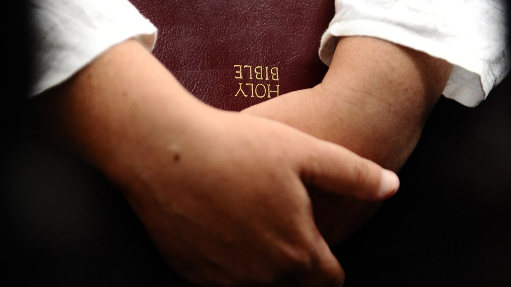 A woman holds a Bible. (Photo by Robertus Pudyanto/Getty)