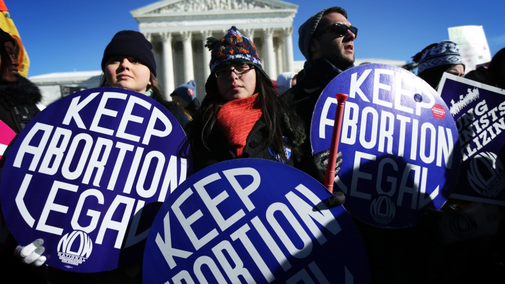 Pro-choice activists hold signs in front of the U.S. Supreme Court January 22, 2014 on Capitol Hill in Washington, D.C.