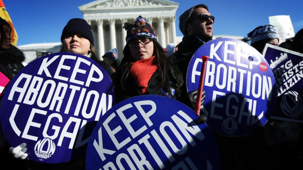 Pro-choice activists hold signs as marchers of the annual March for Life arrive in front of the U.S. Supreme Court on Jan.22, 2014 on Capitol Hill in Washington, DC