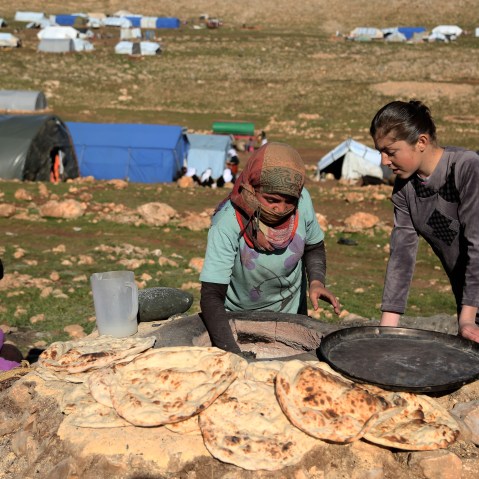 Yezidi women bake bread on the outskirts of Sinjar mountain, Mosul, March 2, 2015, after fleeing from ISIS attacks to a shelter in the Sinjar Mountain. (Photo by Emrah Yorulmaz/Anadolu Agency/Getty)