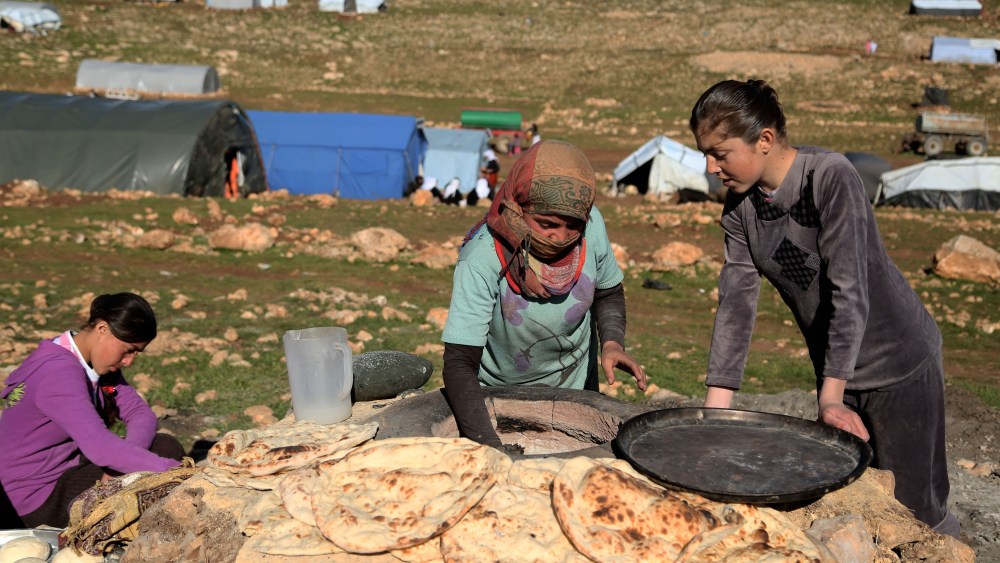 Yezidi women bake bread on the outskirts of Sinjar mountain, Mosul, March 2, 2015, after fleeing from ISIS attacks to a shelter in the Sinjar Mountain. (Photo by Emrah Yorulmaz/Anadolu Agency/Getty)