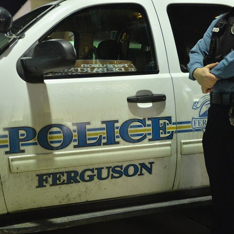 A Ferguson police officer stands on watch as protestors demonstrate outside the Ferguson Police Department in Ferguson, Mo. on March 4, 2015. (Photo by Michael B. Thomas/Getty)