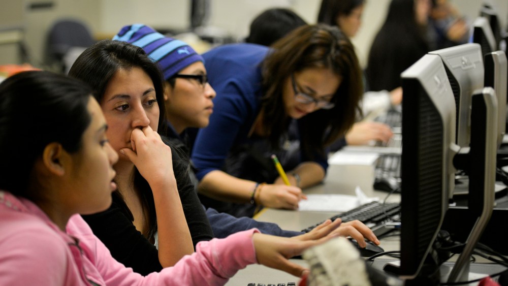 Daniela Martinez, 2nd from L, reads the college essay of undocumented high school student Seila, the only name she wishes to use, at Washington Lee High School on Jan. 23, 2014, in Arlington, VA.