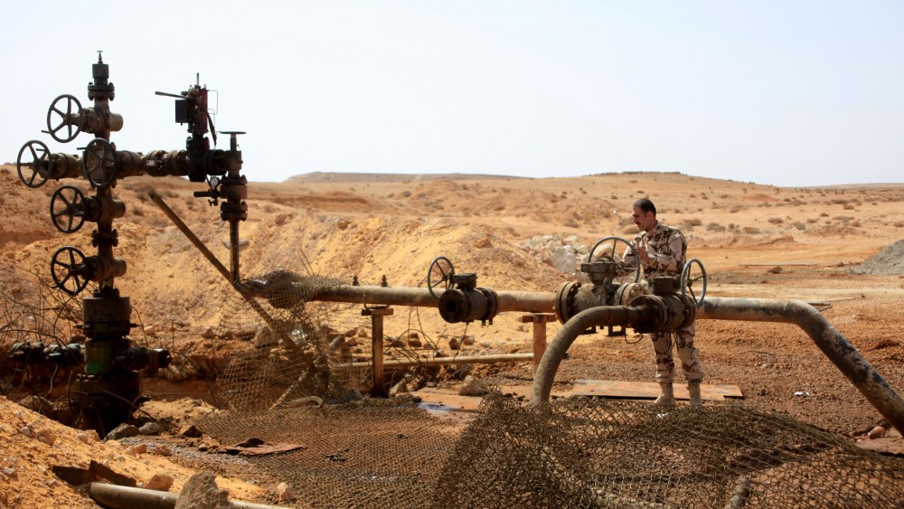 Syrian government soldier stands next to a well at Jazel oil field, after retaking the area from Islamic State fighters on March 9, 2015. Recent US-led coalition air strikes have frequently targeted oil facilities run by IS. (Photo by STR/AFP/Getty)