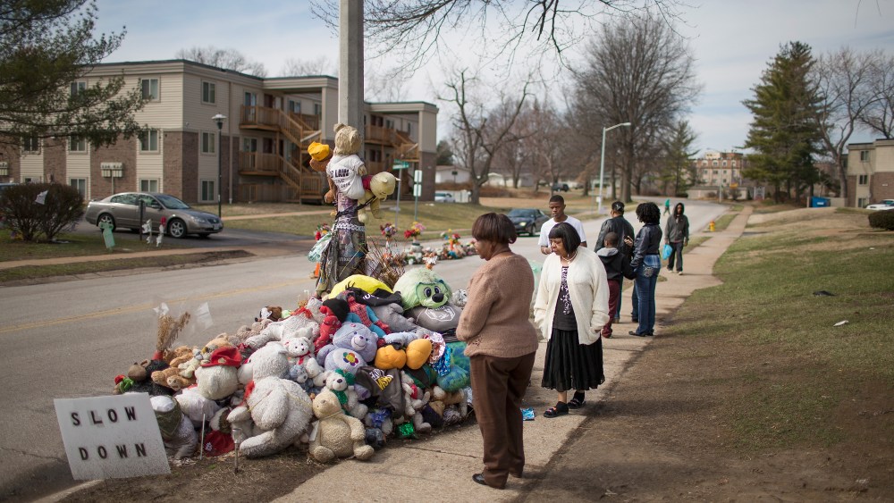 Visitors look over a memorial to Michael Brown outside the Canfield Green apartments where he was shot and killed by a police officer last August on March 14, 2015 in Ferguson, Mo. (Photo by Scott Olson/Getty)