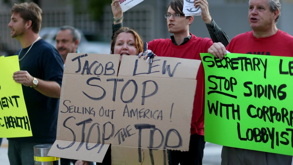 Union members and community activists protest outside the Miami Dade College where the Greater Miami Chamber of Commerce and the college were hosting a moderated conversation with U.S. Secretary of the Treasury Jacob Lew on March 20, 2015 in Miami, Fla.