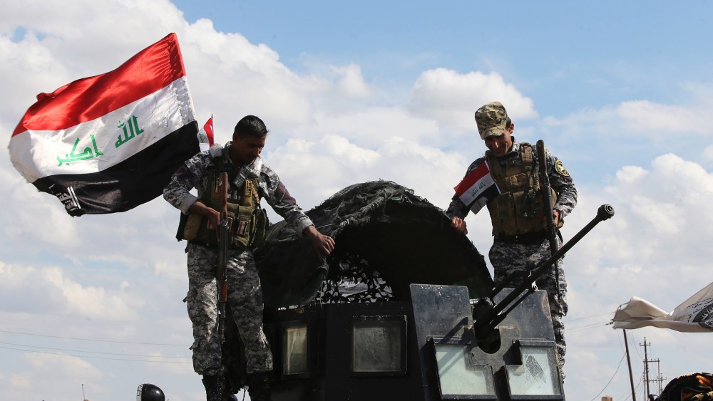 Iraqi policemen stand on March 22, 2015 over an army vehicle at a checkpoint at the entrance of Al-Alam, a flashpoint town north of Tikrit along the Tigris river. (Photo by Ahmad Al-Rubaye/AFP/Getty)