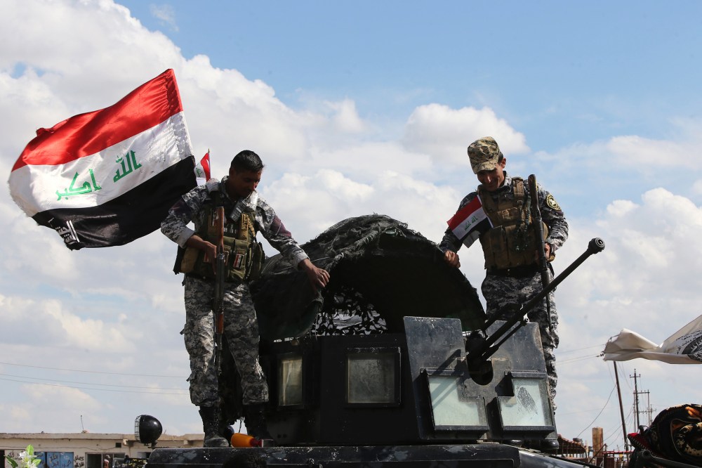 Iraqi policemen stand on March 22, 2015 over an army vehicle at a checkpoint at the entrance of Al-Alam, a flashpoint town north of Tikrit along the Tigris river. (Photo by Ahmad Al-Rubaye/AFP/Getty)