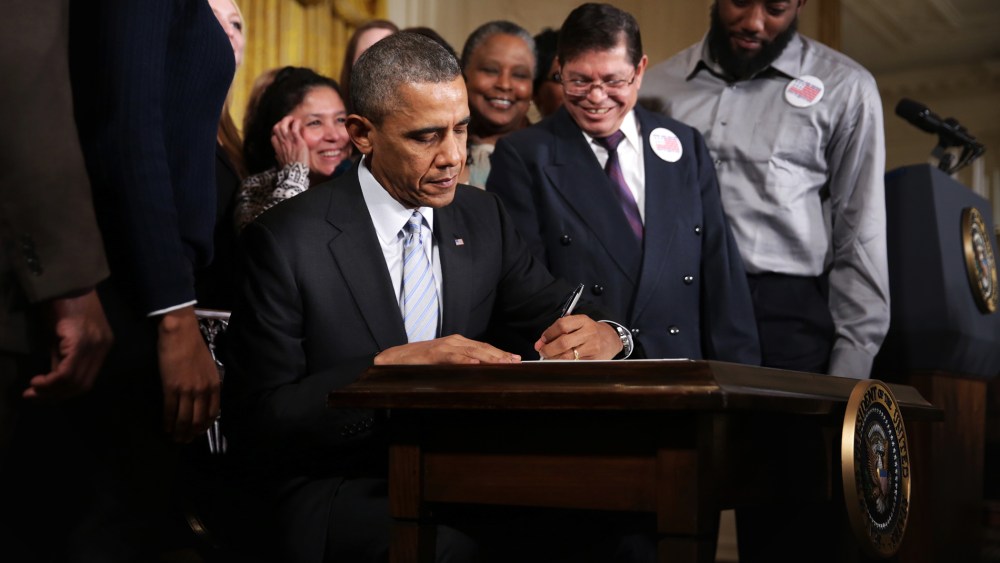 U.S. President Barack Obama signs an executive order to raise the minimum wage for federal contractors, Feb. 12, 2014.