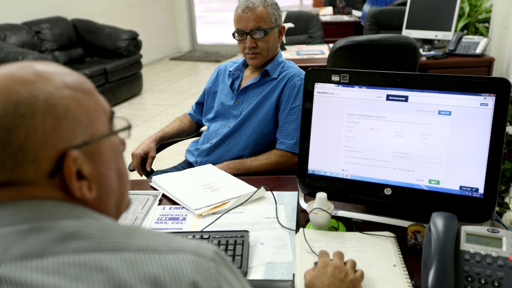 Hisham Uadadeh enrolls in a health insurance plan under the Affordable Care Act with the help of A. Michael Khoury in Miami, Feb. 13, 2014.