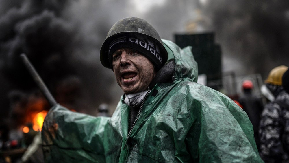 A protester stands behind barricades during clashes with police on February 20, 2014 in Kiev.