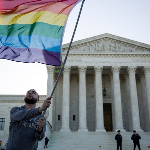 Same-sex marriage supporter Vin Testa, of Washington, DC, waves a rainbow pride flag near the Supreme Court, April 28, 2015 in Washington, DC.