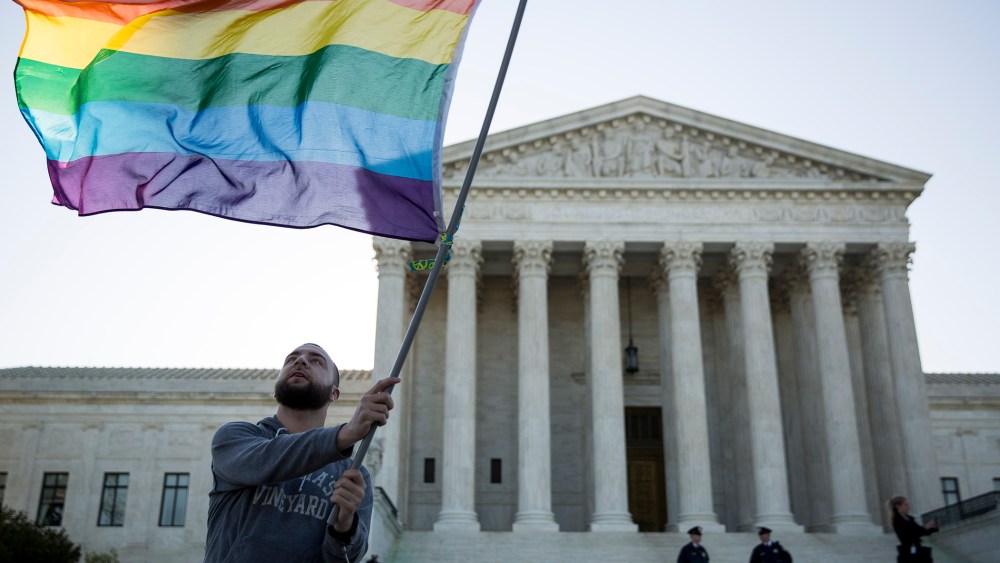 Same-sex marriage supporter Vin Testa, of Washington, DC, waves a rainbow pride flag near the Supreme Court, April 28, 2015 in Washington, DC.