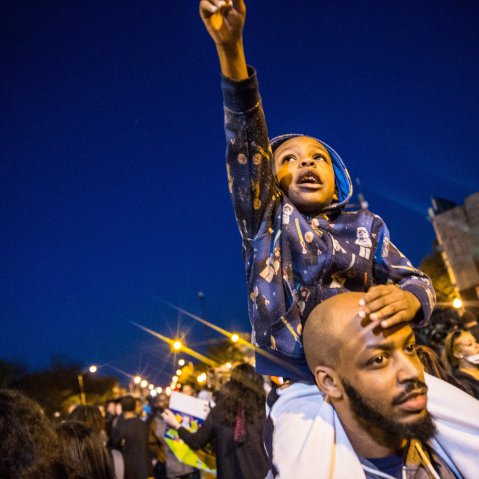 Protesters hang out front of riot police minutes before a mandatory, city-wide curfew of 10 p.m. near the CVS pharmacy that was set on fire yesterday during rioting after the funeral of Freddie Gray, on April 28, 2015 in Baltimore, Md.