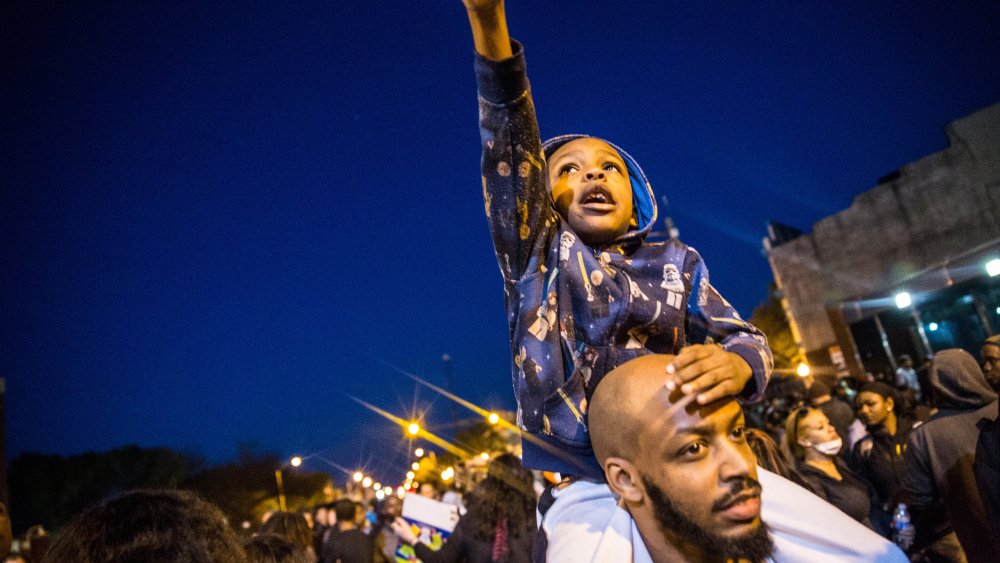Protesters hang out front of riot police minutes before a mandatory, city-wide curfew of 10 p.m. near the CVS pharmacy that was set on fire yesterday during rioting after the funeral of Freddie Gray, on April 28, 2015 in Baltimore, Md.