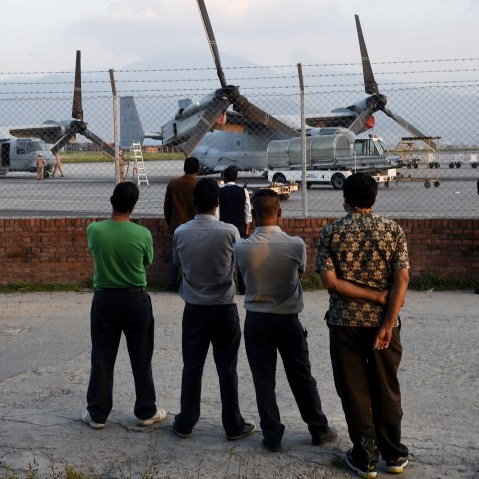 Nepalese men watch US military Osprey aircraft after they landed at Kathmandu's international airport on May 3, 2015. (Photo by Roberto Schmidt/AFP/Getty)