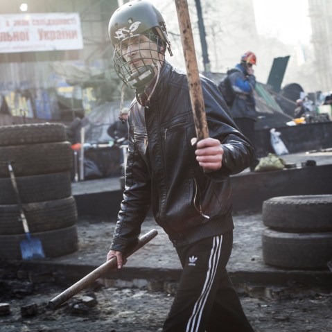 Anti-government protester walks by the barricade on Hrushevskoho street near Maidan Square in Kiev, Feb. 21, 2014.