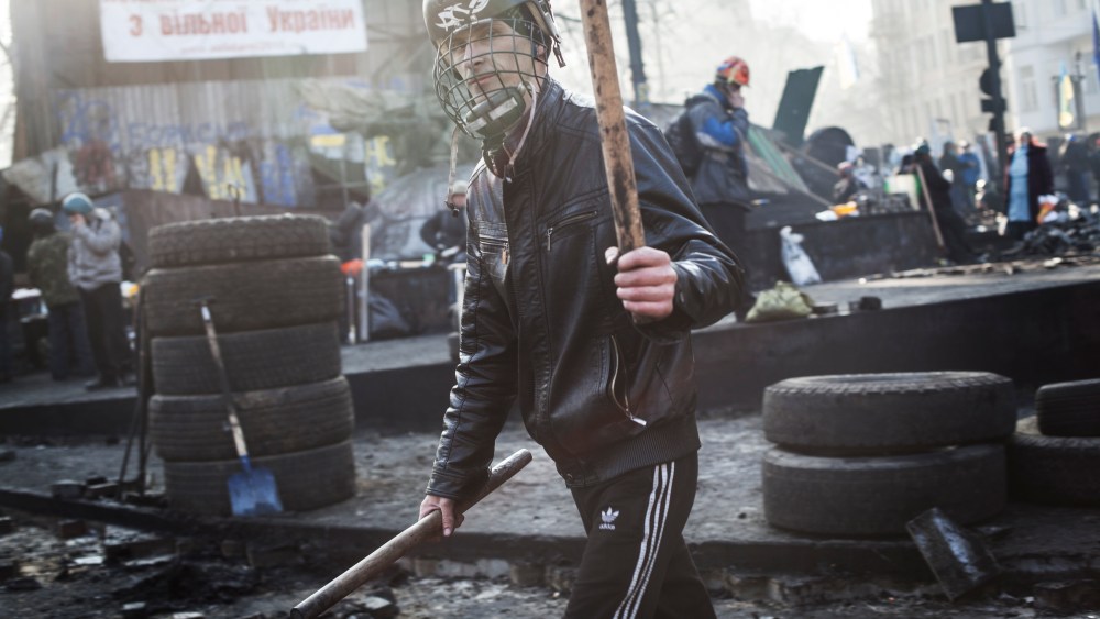 Anti-government protester walks by the barricade on Hrushevskoho street near Maidan Square in Kiev, Feb. 21, 2014.