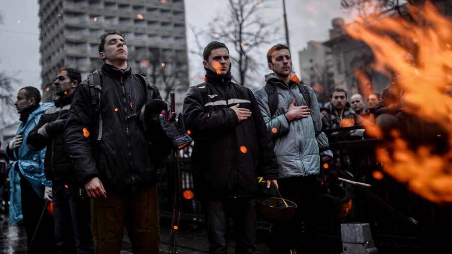 Anti-government protesters react after the vote of the Ukrainian Parliament as they rally outside the parliament building in Kiev on February 22, 2014.