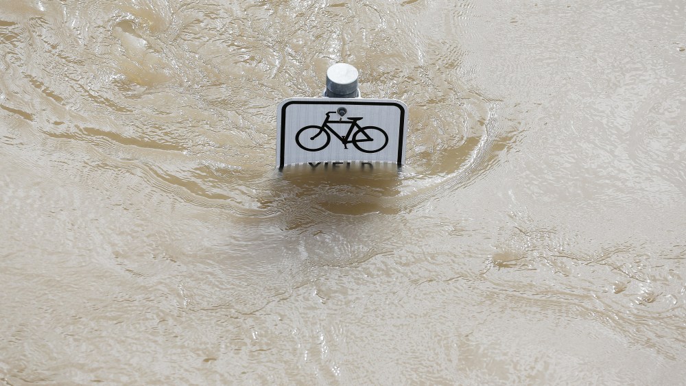 Water is seen at the top of a sign along a bike path near Memorial Drive in Houston, Texas on May 26, 2015. (Photo by Aaron M. Sprecher/AFP/Getty)