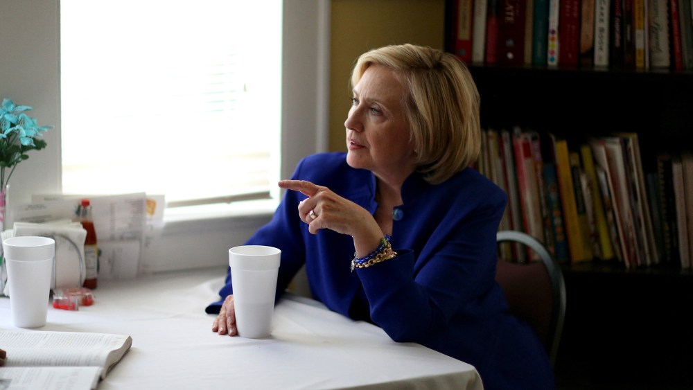 Democratic Presidential candidate Hillary Clinton sits with a customer as she visits the Main Street Bakery on May 27, 2015 in Columbia, S.C. (Photo by Joe Raedle/Getty)
