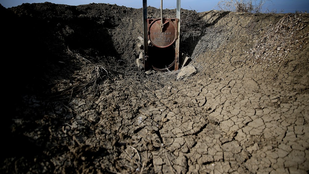 Dried and cracked earth is visible in an irrigation channel on Feb. 25, 2014 in Firebaugh, Calif.