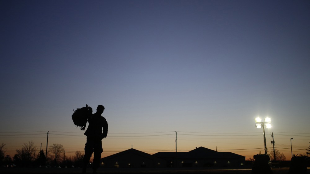 A soldier grabs his rucksack following a homecoming ceremony, Feb. 27, 2014, in Fort Knox, Ky.