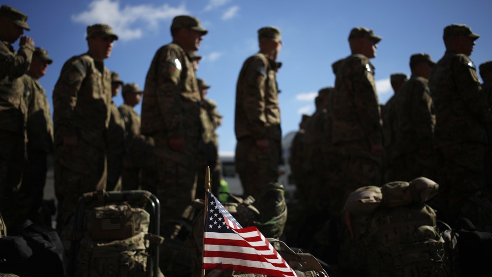 An American flag flies from the rucksack of soldier outside a homecoming ceremony on Fort Knox on Thursday, February 27, 2014 in Fort Knox, Ky.