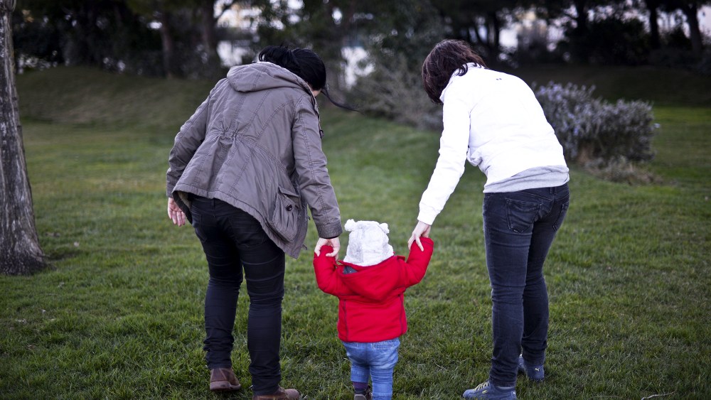 Same sex couple Olga Miranda (R) and Matilde Custodio (L) hold their daughter Carolina during a walk, February 23, 2014.