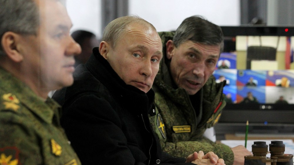 Russian President Vladimir Putin (C) and Defense Minister Sergei Shoigu (L) watch a military exercises at Kamenka polygon on March 3, 2014 near Saint Petersburg, Russia.