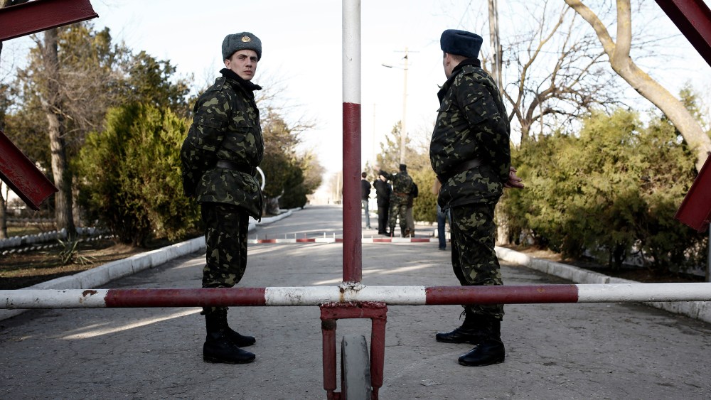 Ukrainian soldiers wait in front of the main entrance of the barracks at the Ukrainian military base in Eupatoria, taken under control by Russian army forces in Crimea on March 5, 2014.