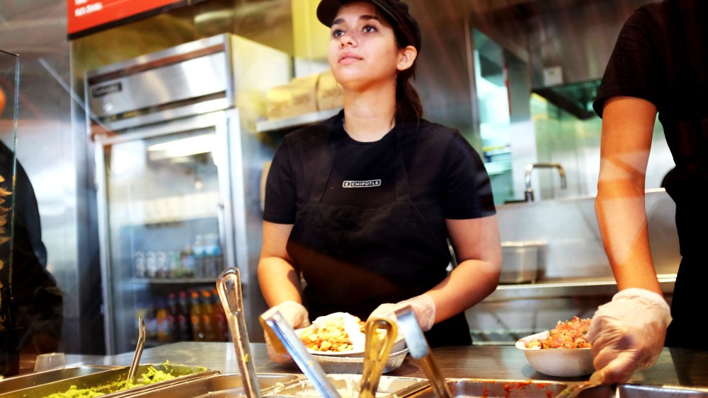 A restaurant worker fills an order at a Chipotle restaurant on March 5, 2014 in Miami, Florida.