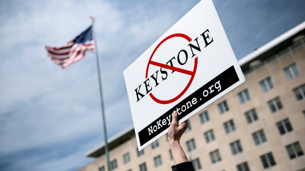 An activist holds up a sign outside the State Department during a protest of the Keystone XL pipeline on March 7, 2014 in Washington.