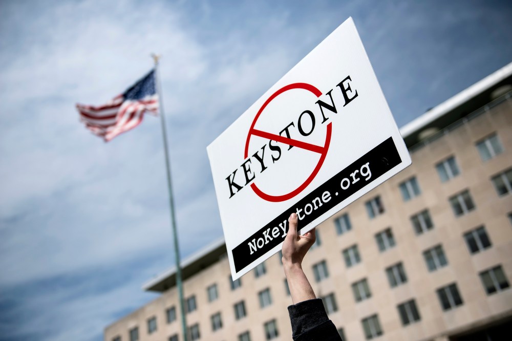 An activist holds up a sign outside the State Department during a protest of the Keystone XL pipeline on March 7, 2014 in Washington.